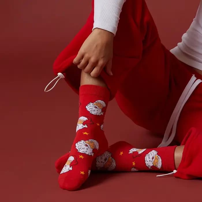 1 paire de chaussettes unisexes avec semelles rouges festives ornées de motifs Père Noël et d'étoiles